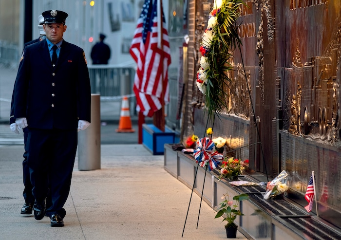 (Craig Ruttle | AP Photo) New York City firefighters take a position in front of a memorial on the side of a firehouse adjacent to One World Trade Center and the 9/11 Memorial site during ceremonies commemorating the 18th anniversary of the 9/11 terrorist attacks in New York on Wednesday, Sept. 11, 2019.
