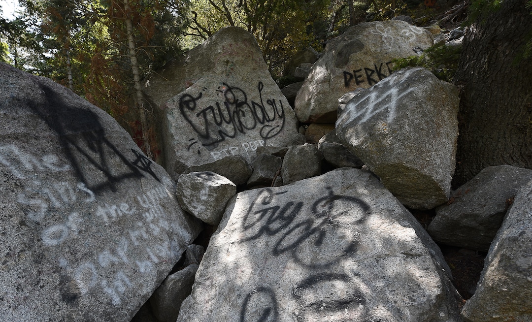 (Francisco Kjolseth  |  The Salt Lake Tribune)  Graffiti has proliferated in lower Little Cottonwood Canyon, where vandals, often wielding cans of fluorescent-colored spray paint, have covered granite faces, trees and structures. The vandalism is particularly apparent along the Temple Quarry Trail and the creek at the Moon Rock swimming hole and former pavilion site. Volunteers using donated equipment and solvents spend thousands of hours removing the paint from the rocks only to see graffiti return to the same faces or on rock nearby.