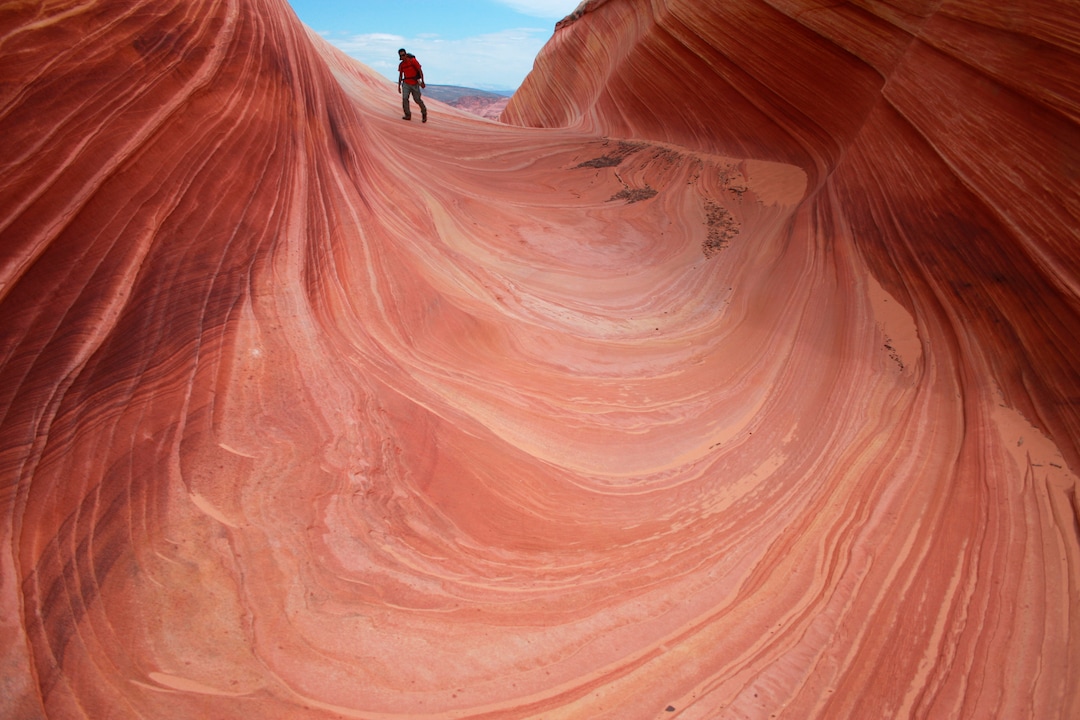 FILE - In this May 28, 2013, file photo, a hiker walks on a rock formation known as The Wave in the Vermilion Cliffs National Monument  along the Arizona-Utah border. (AP Photo/Brian Witte, File)
