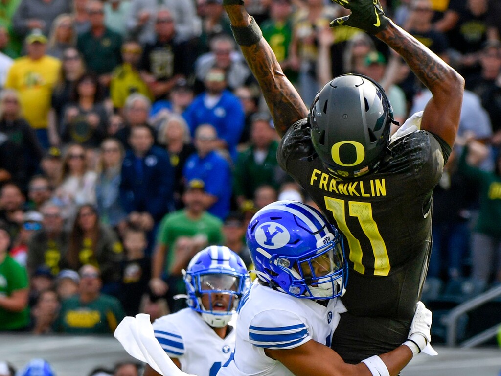 Oregon wide receiver Troy Franklin (11) hauls in a catch despite tight coverage by BYU defensive back Jakob Robinson during the first half of an NCAA college football game, Saturday, Sept. 17, 2022, in Eugene, Ore. (AP Photo/Andy Nelson)