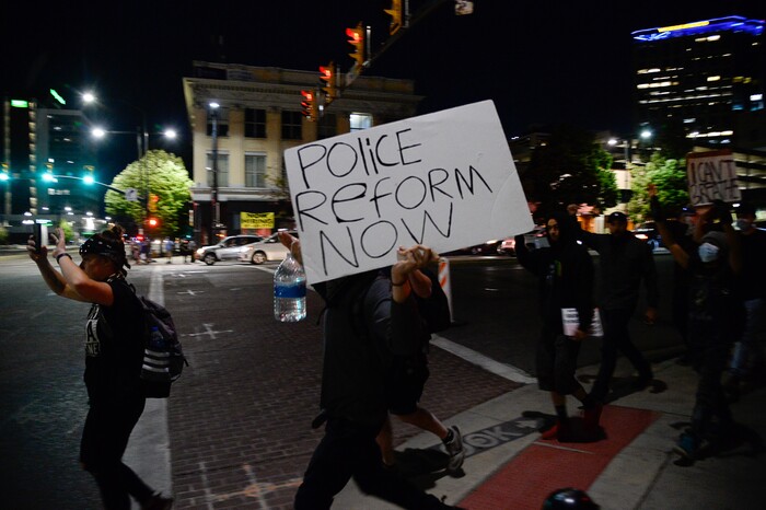 (Francisco Kjolseth  |  The Salt Lake Tribune) Protesters walk down State Street in Salt Lake City as police line up to enforce a mandatory curfew on Monday, June 1, 2020, following violence and unrest over the weekend due to the death of George Floyd by police.