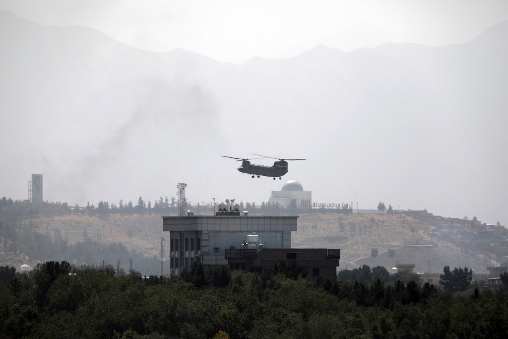 (Rahmat Gul | The Associated Press) A U.S. Chinook helicopter flies over the U.S. Embassy in Kabul, Afghanistan, Sunday, Aug. 15, 2021. Helicopters are landing at the U.S. Embassy in Kabul as diplomatic vehicles leave the compound amid the Taliban advanced on the Afghan capital.