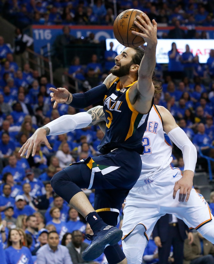 Utah Jazz guard Ricky Rubio, left, shoots in front of Oklahoma City Thunder center Steven Adams right, int he second half of Game 1 of an NBA basketball first-round playoff series in Oklahoma City, Sunday, April 15, 2018. (AP Photo/Sue Ogrocki)