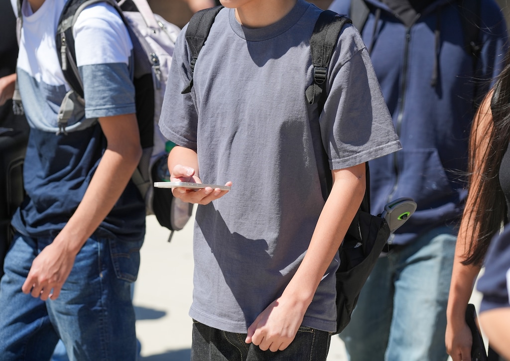 (Chris Samuels | The Salt Lake Tribune) Students leaving Granger High School in West Valley City unlock their cell phones after exiting the school’s doors, Monday, Aug. 26, 2024.