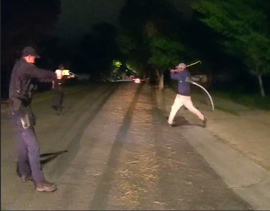 (West Valley City Police) This still image from body camera footage shows a man approaching police with a crowbar in West Valley City, May 10, 2021.