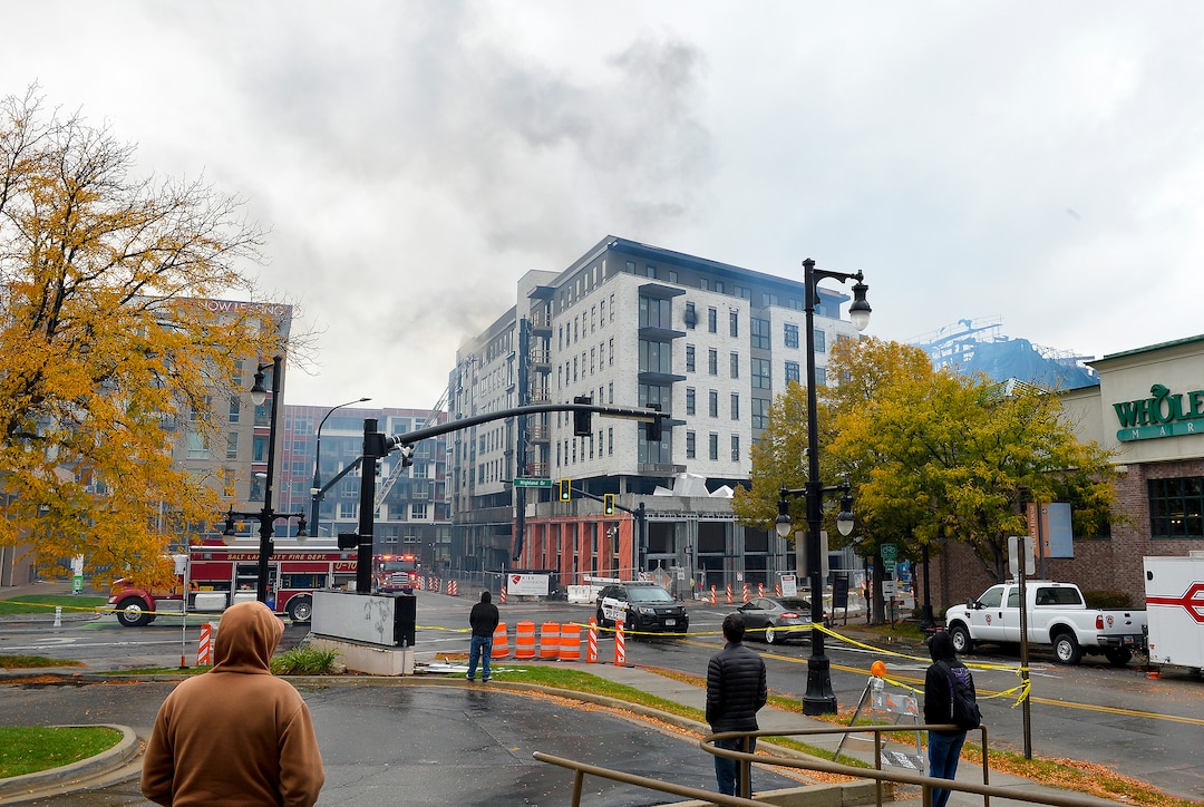 (Chris Samuels | The Salt Lake Tribune) People watch as a fire in a new construction of apartment residences continues to burn in Sugar House, Wednesday, Oct. 26, 2022.