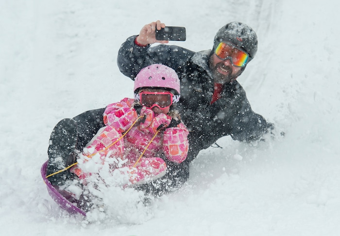 (Rick Egan  |  The Salt Lake Tribune)      
 Mark Fehlberg, sleds down the hill with his daughter Amelia 7, at Popperton Park, Monday, Jan. 21, 2019.


