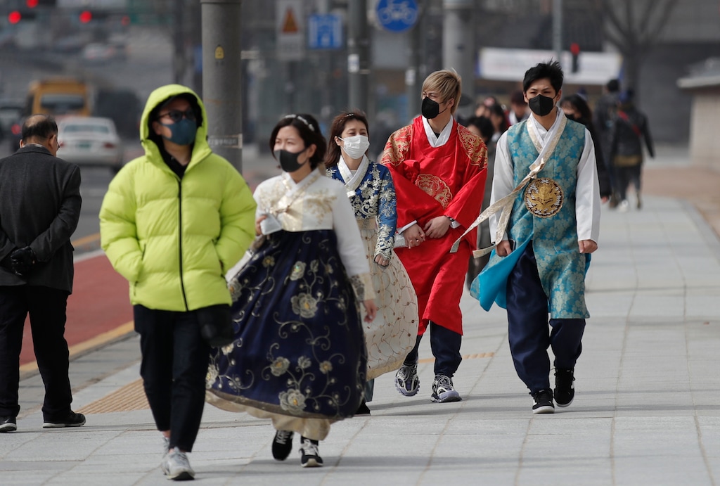 (Lee Jin-man | AP) Visitors wearing face masks walk near the Gwanghwamun, the main gate of the 14th-century Gyeongbok Palace, and one of South Korea's well-known landmarks, in Seoul, South Korea, Saturday, Feb. 22, 2020. South Korea on Saturday reported a six-fold jump in viral infections in four days to 346, most of them linked to a church and a hospital in and around the fourth-largest city where schools were closed and worshipers and others told to avoid mass gatherings.