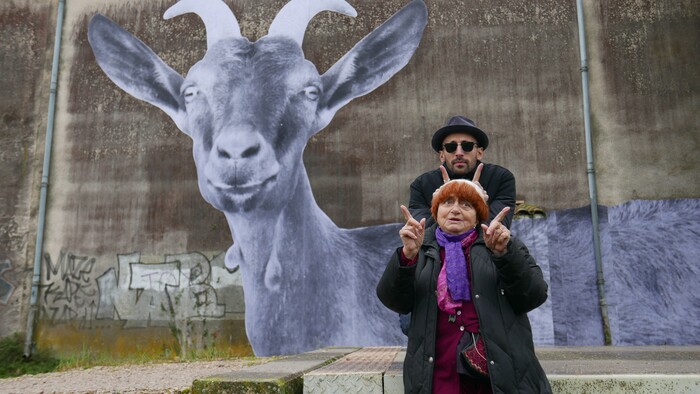 (Photo courtesy of Cohen Media Group) French filmmaker Agnes Varda (front) and Paris street artist JR pose in front of a photo of a goat, that Varda took and JR blew up to building size, in the documentary "Faces Places."
