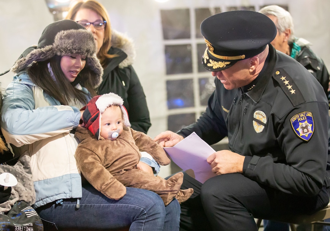 (Keith Johnson | Special to The Tribune) South Salt Lake Police Chief Jack Carruth talks to Liz Romrell and her son Jackson (4 months) before a candlelight vigil Dec. 2, 2018, at the Columbus Community Center in South Salt Lake for Liz's husband, fallen Officer David Romrell, a South Salt Lake police officer killed in the line of duty Nov. 24, when he was struck by a car driven by a fleeing suspect. Several hundred members of the community attended the vigil including family, friends, South Salt Lake Mayor Cherie Wood and representatives from the Utah Highway Patrol, Unified Police and Unified Fire.