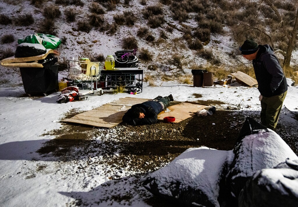 (Rick Egan | The Salt Lake Tribune) Shawn Spalding talks to a man laying on a piece of cardboard during the Salt Lake County point-in-time count on Friday, Jan. 27, 2023. Despite an increase in people experiencing homelessness in Utah, officials say deeply affordable housing has lead to a smaller increase compared to other states.
