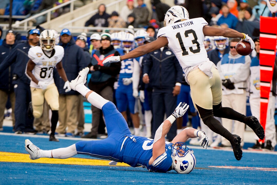 (Jeremy Harmon  |  The Salt Lake Tribune) Western Michigan Broncos wide receiver Keishawn Watson (13) jumps over Brigham Young Cougars running back Tanner Jacobson (25) as BYU faces the Western Michigan Broncos in the Famous Idaho Potato Bowl in Boise, Idaho, on Friday, Dec. 21, 2018.