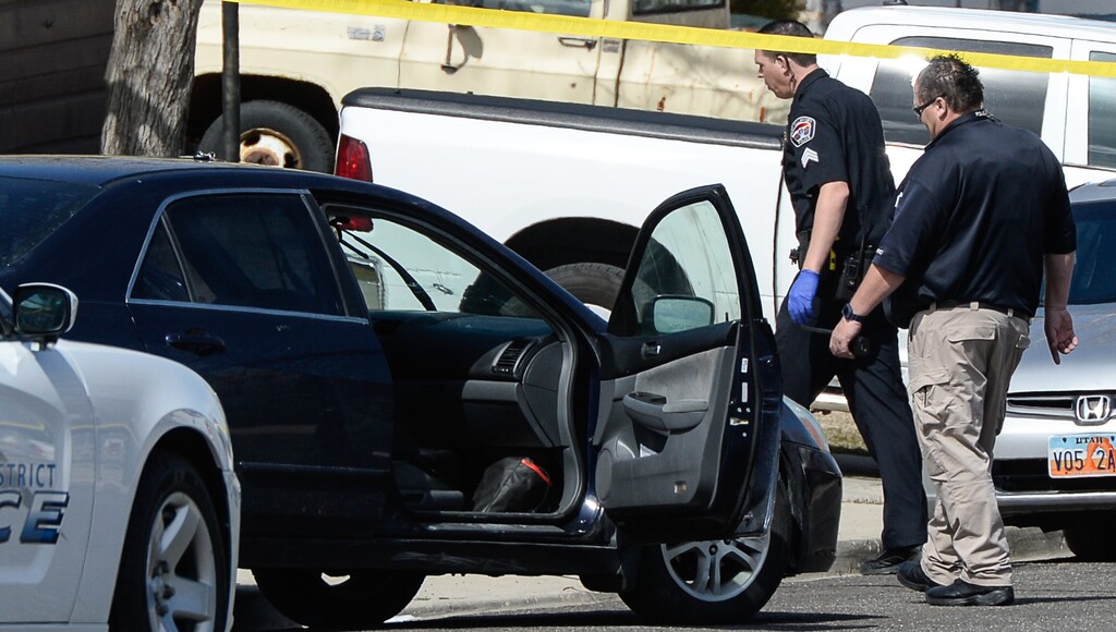 (Francisco Kjolseth  |  The Salt Lake Tribune)  A bullet hole can be seen in the windshield of a black sedan as Investigators comb the scene where a Granite School District police officer shot a driver on Tuesday afternoon, March 20, 2018. While on patrol near Hunter High School, the officer noticed a car full of teenagers and smelled marijuana. When he approached the car lurched and he ended up on the hood. The driver was shot and four other teens in the car fled the scene.