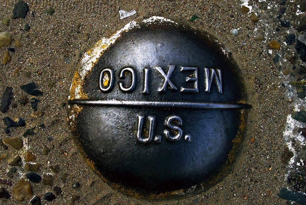 FILE - In this April 10, 2000, file photo, a marker embedded in the pavement marks the imaginary line between the United States and Mexico at the San Ysidro border checkpoint between San Diego, Calif., and Tijuana, Mexico. The rare conjunction of two major cities, Tijuana and San Diego, with Los Angeles to the north, make it one of the busiest border crossings on the planet. The U.S. National Guard faces a vastly different environment than it did on its last two deployments to the border with Mexico, with far fewer illegal crossings and more Central Americans than Mexicans coming. (AP Photo/Damian Dovarganes, File)