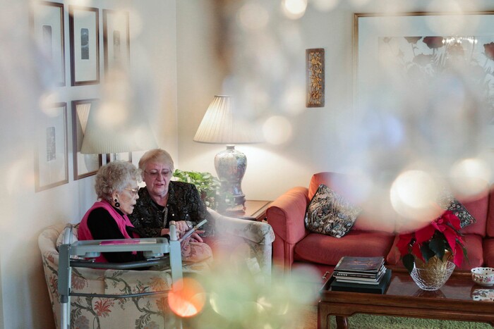 This photo taken Jan. 5, 2018, shows Marian Christensen, left, and Felicity Varkevisser writing a list for grocery shopping in Christensen's home in Provo, Utah. Christensen lives alone in her home and is turning 98-years-old next month. (Evan Cobb/The Daily Herald via AP)
