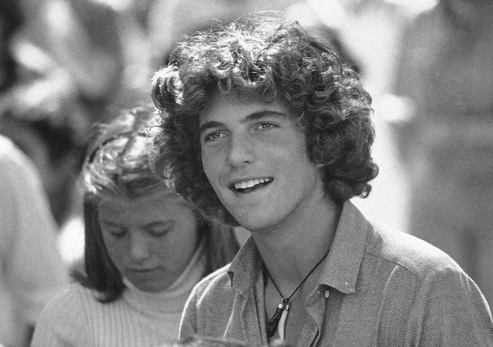 FILE - In this Sept. 10, 1979 file photo, John Kennedy Jr. waits in registration line at Brown University in Providence, R.I., to register for his first year of college. A documentary film on John Kennedy Jr.'s life opens Friday, July 22, 2016, in select theaters. It also airs on Spike TV at 9 p.m. EDT on Aug. 1, and a DVD release is set for Aug. 16. (AP Photo/Constance Brown, File)