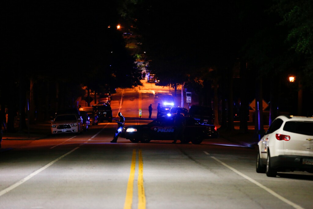 Police block off streets in front of a police station at Georgia Tech where protests happened earlier and at least one police car was burned on Monday, Sept. 18, 2017, in Atlanta. Protesters were demonstrating against the shooting, which resulted in a fatality, of a student on Saturday. (AP Photo/Kevin D. Liles)