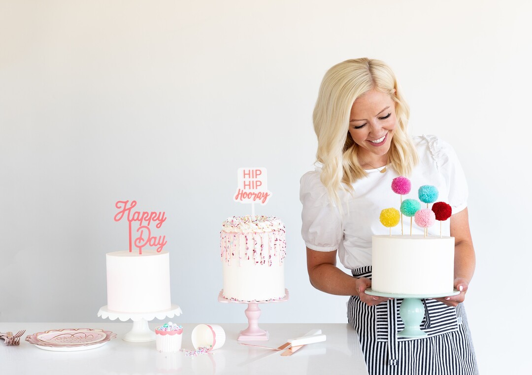 (Photo by Trina Harris Photography | Courtesy of Courtney Rich) Courtney Rich poses with some cakes she made featuring cake toppers and other products from her collection with My Mind's Eye.