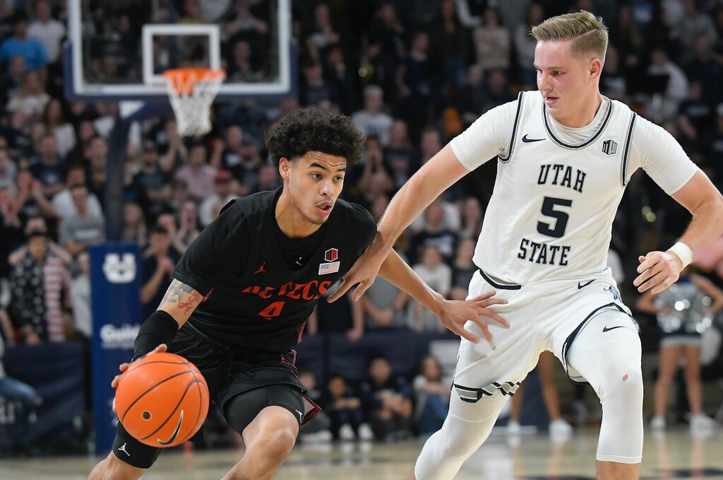 San Diego State guard Trey Pulliam (4) is defended by Utah State guard Sam Merrill during the first half of an NCAA college basketball game Saturday, Jan. 4, 2020, in Logan, Utah. (AP Photo/Eli Lucero)