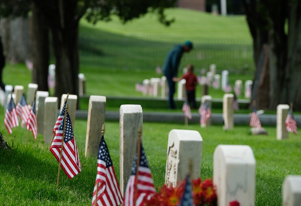 (Francisco Kjolseth  |  The Salt Lake Tribune)  People visit graves during a Memorial Day Ceremony at Fort Douglas Cemetery on Monday, May 27, 2019.