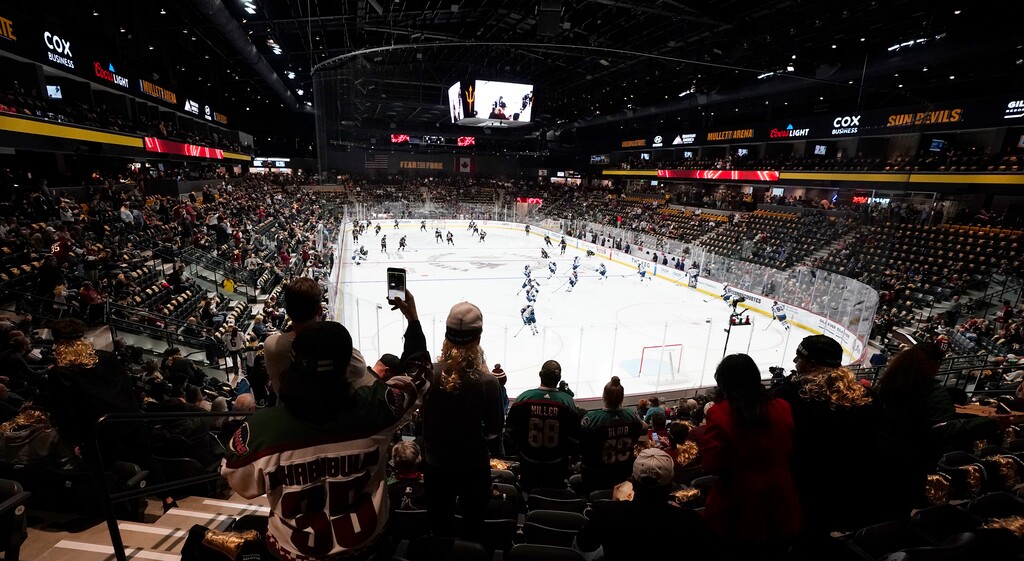 (Ross D. Franklin | AP) Fans watch as players warm up prior to the Arizona Coyotes' home-opening NHL hockey game against the Winnipeg Jets at the 5,000-seat Mullett Arena in Tempe, Ariz., Oct. 28, 2022.