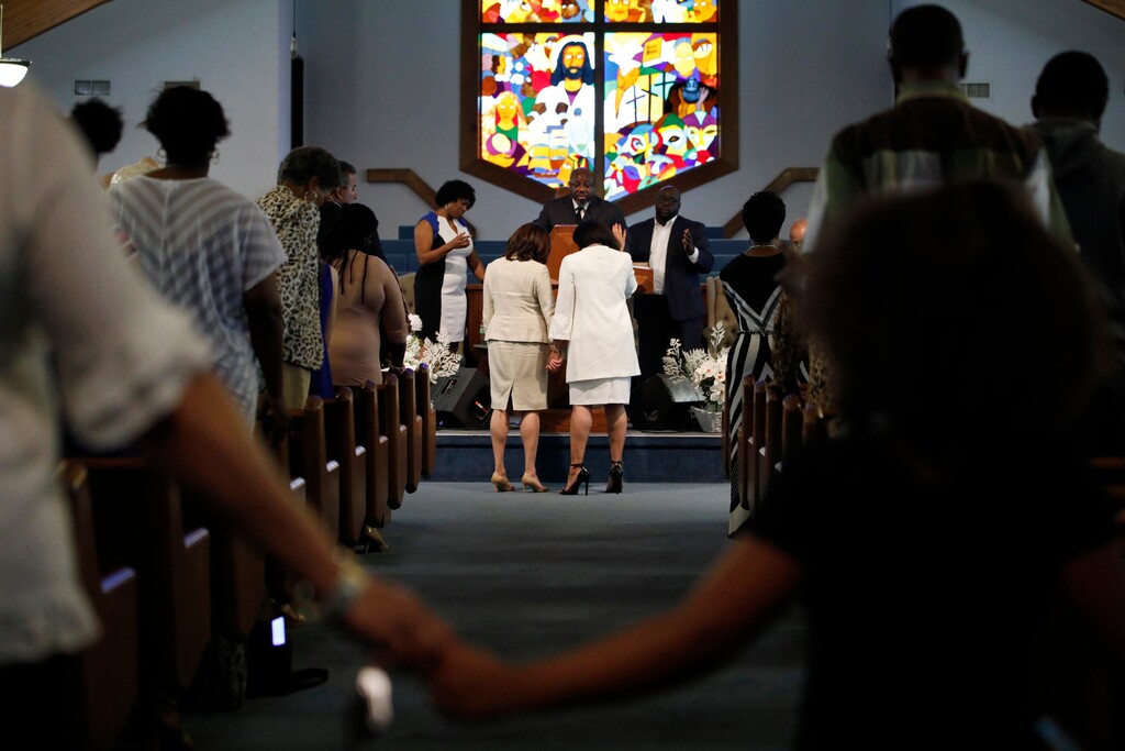 (John Locher | AP file photo) Maya Harris, center right, and members of the Corinthian Baptist Church pray for Democratic presidential candidate Sen. Kamala Harris, D-Calif., center left, during a service in Des Moines, Iowa, Aug. 11, 2019. Soon after Joe Biden tapped Harris as his running mate, some conservatives began trying to portray her as anti-Catholic, a line of attack that President Donald Trump’s campaign continues to amplify as Democrats court Roman Catholic voters.