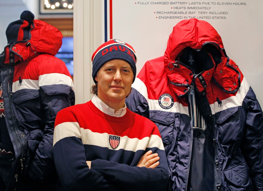 David Lauren poses beside Team USA's Opening Ceremony parka, which features a battery-powered heating element inside to keep athletes warm during the Winter Olympics in Pyeongchang, South Korea, Monday, Jan. 22, 2018, in New York. (AP Photo/Kathy Willens)