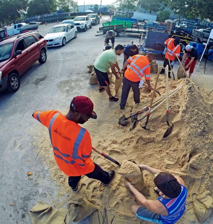 (Red Huber/Orlando Sentinel via AP) Residents fill up sandbags Thursday, Sept. 7, 2017, in Orlando, Fla., as they prepare for Hurricane Irma. Long lines of vehicles waited for hours to get a 10 sandbag limit at the City of Orlando Public Works.
