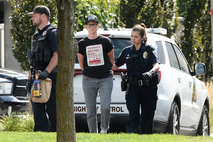 (Francisco Kjolseth  |  The Salt Lake Tribune)  Activist Lesley Ann Shaw is removed from a building where activists staged a protest against a private prison company with contracts to hold undocumented immigrants on Thursday, July 12, 2018, at the headquarters of Management and Training Corporation in Centerville.