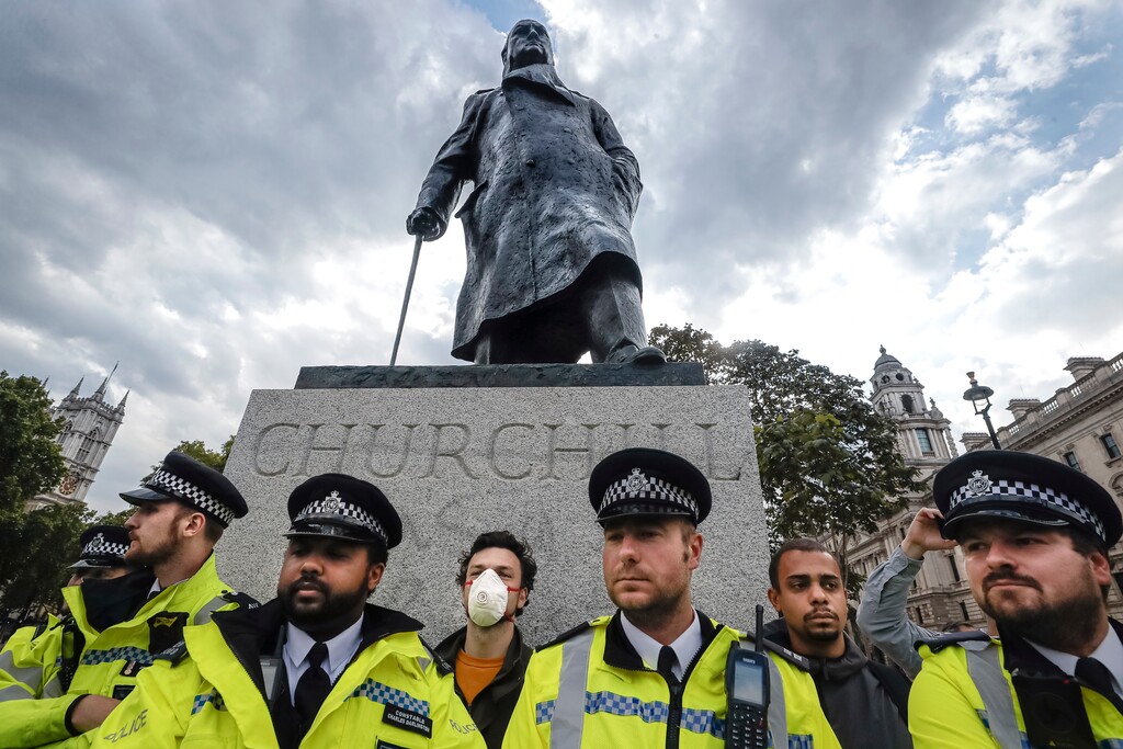 (Kirsty Wigglesworth | AP file photo)  Police officers stand in front of the Winston Churchill statue during a rally in Parliament Square in London, Tuesday, June 9, 2020.