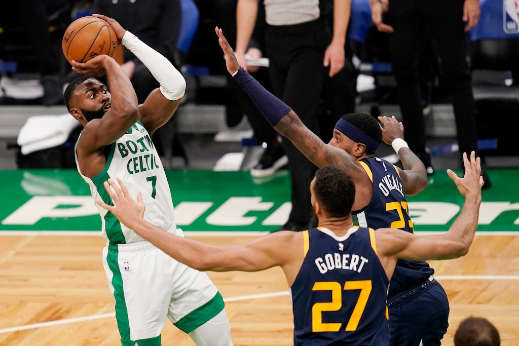 Boston Celtics guard Jaylen Brown (7) shoots over Utah Jazz center Rudy Gobert (27) and forward Royce O'Neale, rear right, during the first half of an NBA basketball game Tuesday, March 16, 2021, in Boston. (AP Photo/Charles Krupa)
