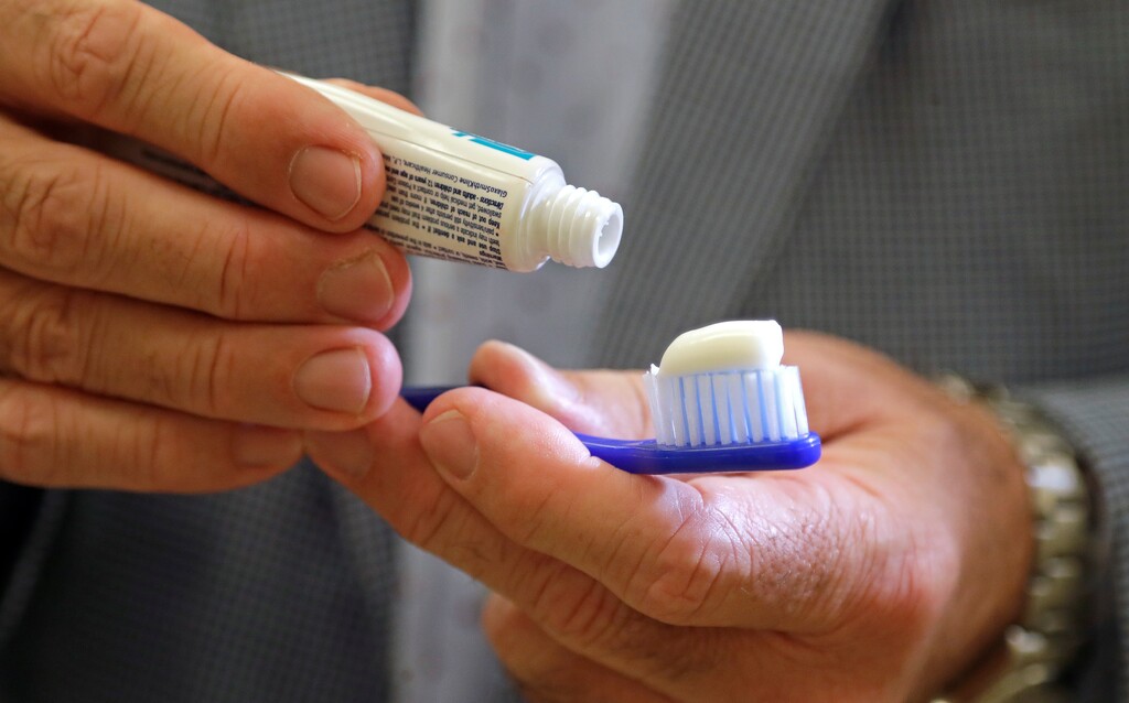 A dentist holds a toothbrush and toothpaste.  (AP Photo/Elaine Thompson)