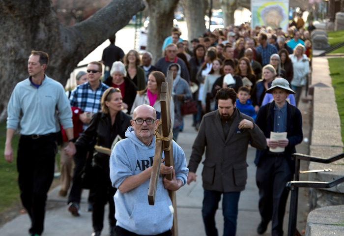 (Rick Egan  |  The Salt Lake Tribune)     Christian faithful follow Alex Bury, from Sunset, as he carries the cross along with clergy and members of Christian denominations participate in the annual Good Friday procession through downtown Salt Lake City, Friday, March 30, 2018. The procession commemorating Christ's path to crucifixion has been a tradition of the Salt Lake Council of Churches since 1988. 


