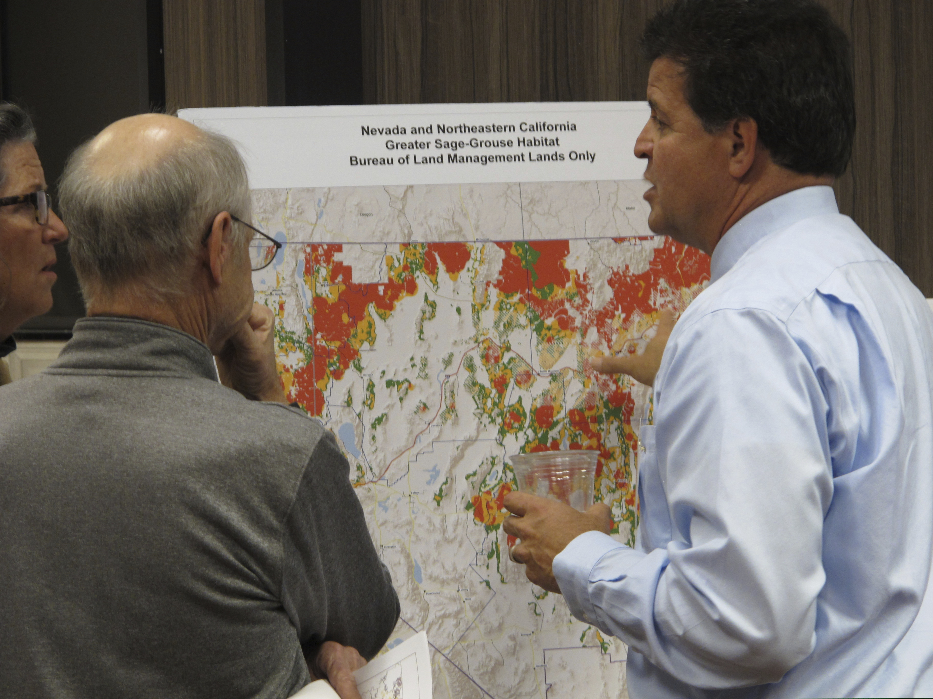 (Scott Sonner | AP file photo) On Nov. 7, 2017, Raul Morales, right, the U.S. Bureau of Land Management's deputy state director for Nevada, looks at a map of sage grouse habitat areas on BLM lands in Nevada and Northeastern California during a public meeting in Sparks, Nev. Federal land managers have withdrawn more than 500 square miles of public land from a swath of eastern Nevada where oil and gas drilling leases were scheduled to be auctioned off on Tuesday, Nov. 12, 2019. Critics say rock-bottom oil prices have led to rank speculation in government leasing of oil and gas drilling rights.