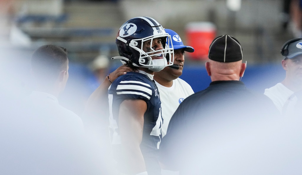 (Bethany Baker  |  The Salt Lake Tribune) Brigham Young Cougars head coach Kalani Sitake puts his arm around Cougars player Ephraim Asiata during a game in 2025. Asiata has been charged with DUI.