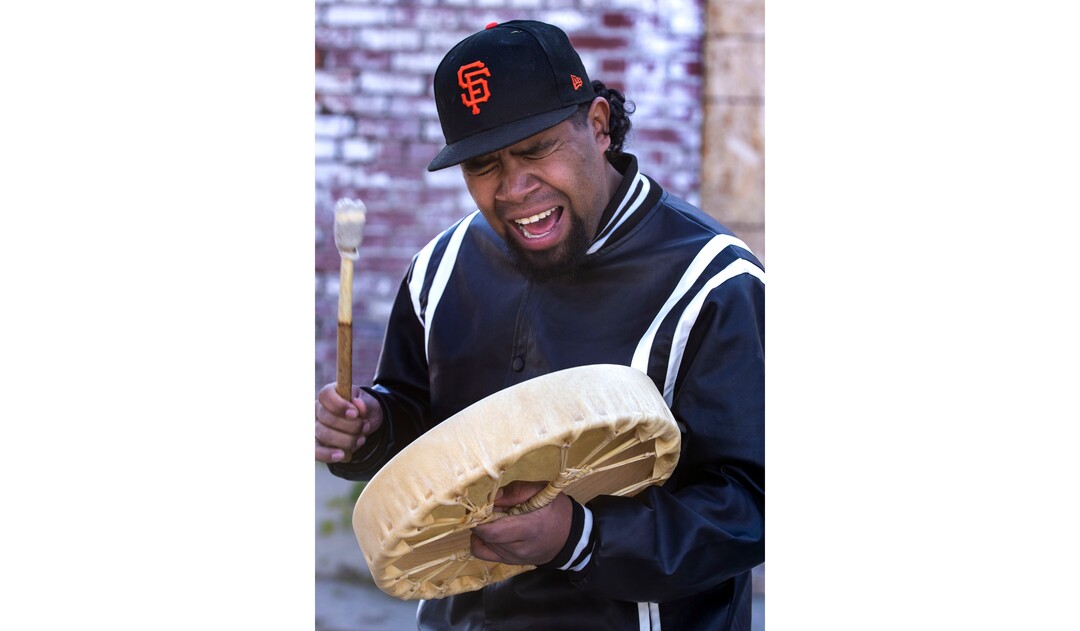 (Rick Egan | The Salt Lake Tribune) Lane Neaman play a drum as he sings a Southern Oklahoma Stye round dance song as Dave John and volunteers with Black Lives for Humanity cook Navajo Tacos, for  a "Gratitude Dinner" for more than 100 people from the unsheltered population, on 500 West in Salt Lake City, onThursday, Nov. 25, 2021.