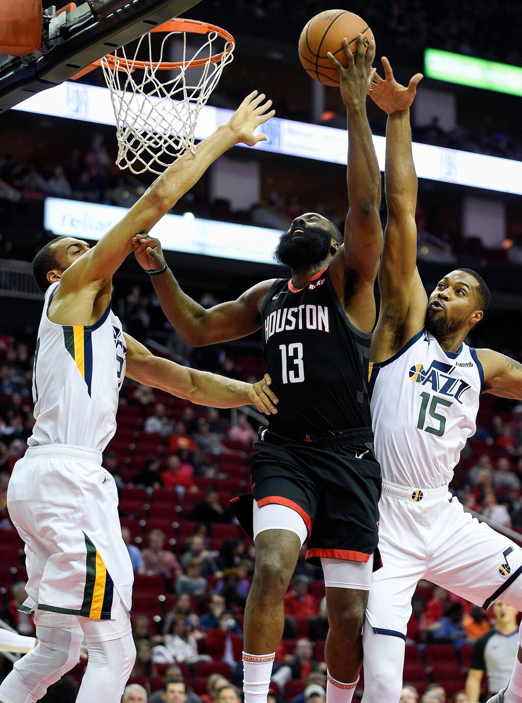 Houston Rockets guard James Harden (13) drives to the basket as Utah Jazz center Rudy Gobert, left, and forward Derrick Favors (15) defend during the first half of an NBA basketball game, Wednesday, Oct. 24, 2018, In Houston. (AP Photo/Eric Christian Smith)
