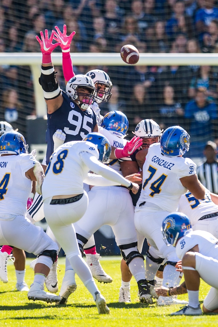 (Chris Detrick  |  The Salt Lake Tribune)  San Jose State Spartans place kicker Bryce Crawford (38) kicks a field past Brigham Young Cougars defensive lineman Khyiris Tonga (95) and Brigham Young Cougars defensive lineman Corbin Kaufusi (90) during the game at LaVell Edwards Stadium Saturday, October 28, 2017.  