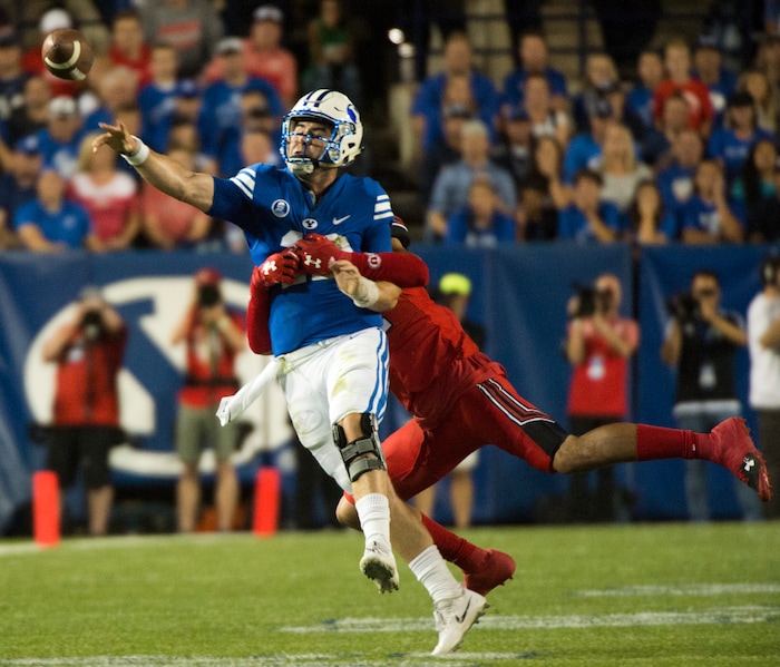 (Rick Egan  |  The Salt Lake Tribune)   Brigham Young Cougars quarterback Tanner Mangum (12) is chased by Utah Utes defensive end Caleb Repp (47), football action BYU vs Utah, at Lavell Edwards Stadium in Provo, Saturday, September 9, 2017.