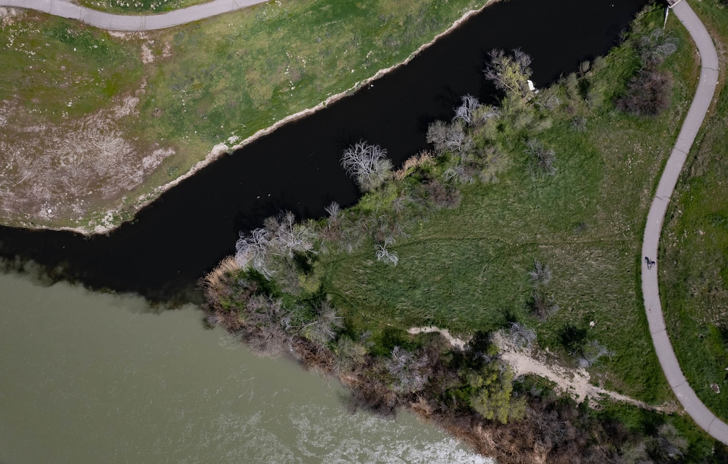 (Francisco Kjolseth | The Salt Lake Tribune) The dark waters of Mill Creek combine with the flow of the Jordan River on Wednesday, April 17, 2024.