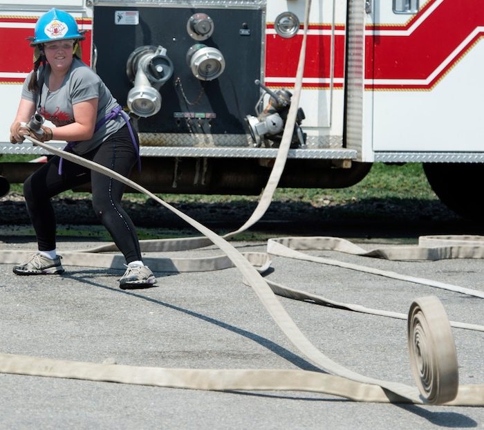 (Rick Egan  |  The Salt Lake Tribune)  Clarissa rolls out a hose during a firefighter skills relay, while attending Camp Fury.  A dozen Utah Girl Scouts participated in a 3-day camp led by female firefighters. Camp Fury Utah was developed in partnership with the Girl Scouts and local fire and police departments, designed to expose teen girls to careers in public safety and other non-traditional jobs. Saturday, August 5, 2017.


