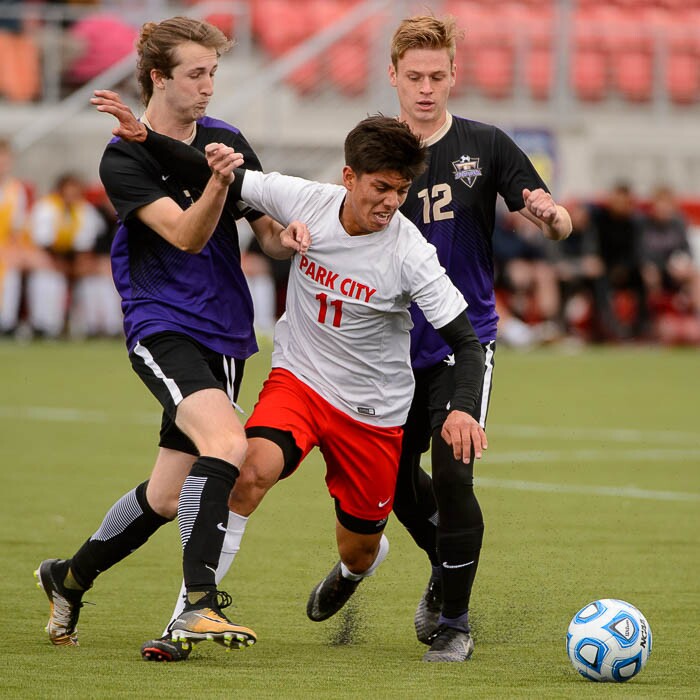 (Trent Nelson | The Salt Lake Tribune)  Desert Hills vs. Park City High School, Saturday May 12, 2018. Park City's Francisco Jaurrieta goes between Desert Hills's Kaler Imlay and Colby Hendrix.