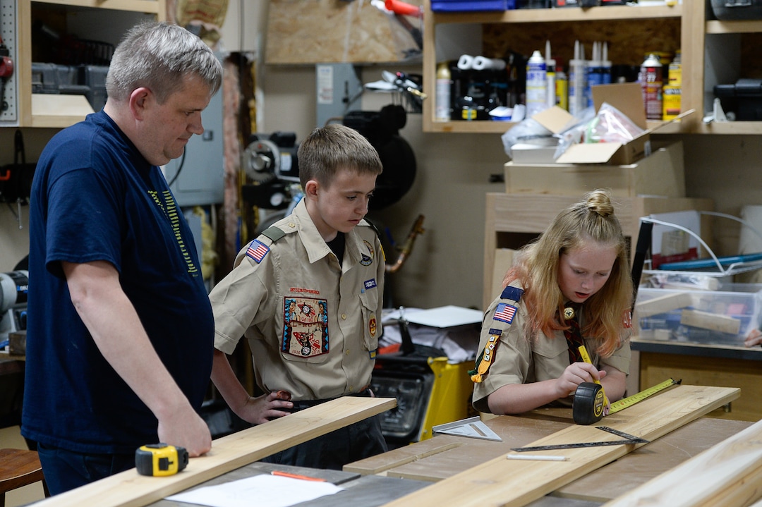 (Francisco Kjolseth  |  The Salt Lake Tribune)  Darwin Cook, Deseret Peak District Chair with the Boy Scouts of America offers guidance to his son Kolbie as he works on his Eagle Scout merit badge with a little help from his sister Miriam in the family garage in Tooele on Monday, May 14, 2018. Miriam is an early adopter into the Cub Scouts, always having expressed an interest in what her brother is doing. 