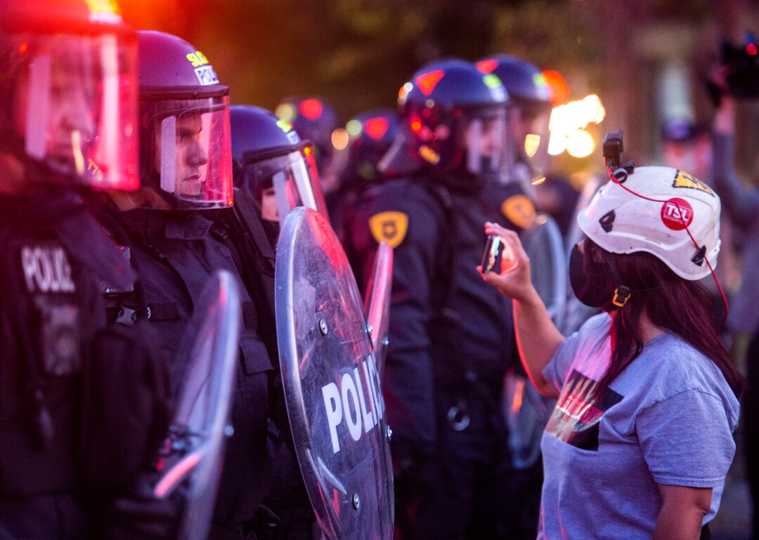 (Rick Egan  |  The Salt Lake Tribune) A lone protester with a cell phone faces a line of police in riot gear on 1300 East near the University of Utah where Mike Pence is debating Kamala Harris on Wednesday, Oct. 7, 2020.