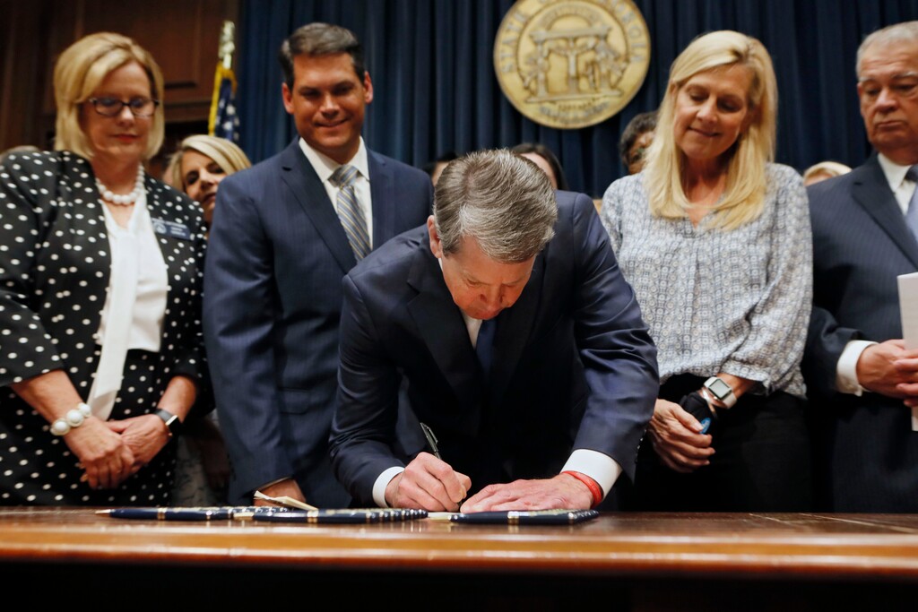 Georgia’s Republican Gov. Brian Kemp, center, signs legislation, Tuesday, May 7, 2019, in Atlanta, banning abortions once a fetal heartbeat can be detected, which can be as early as six weeks before many women know they’re pregnant. Kemp said he was signing the bill “to ensure that all Georgians have the opportunity to live, grow, learn and prosper in our great state.” (Bob Andres/Atlanta Journal-Constitution via AP)