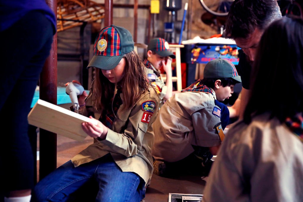 (Charles Krupa | The Associated Press) In a Thursday, March 1, 2018 photo, Tatum Weir, left, sets to drill a pilot hole while building a tool box during a cub scout meeting in Madbury, N.H. Fifteen communities in New Hampshire are part of an "early adopter" program to allow girls to become Cub Scouts and eventually Boy Scouts. Tatum and her twin brother Ian are planning to become the first set of girl-boy siblings to become Eagle Scouts.