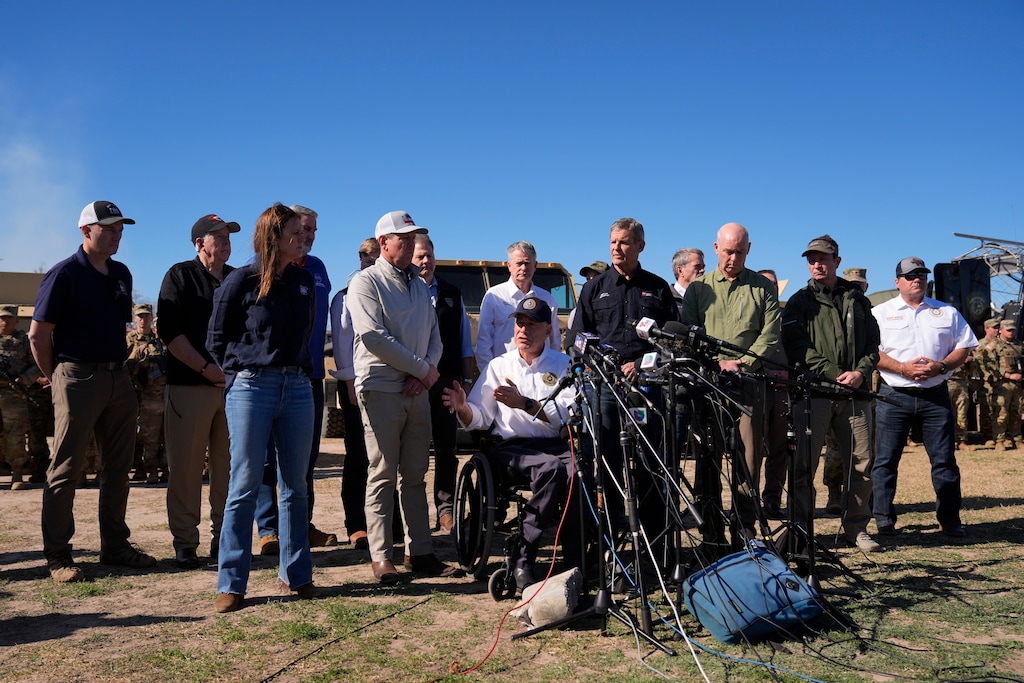 (Eric Gay | AP) Utah Gov. Spencer Cox, far left, stands behind Texas Gov. Greg Abbott, seated center, who is joined by fellow governors during a press conference along the Rio Grande to discuss Operation Lone Star and border concerns, Sunday, Feb. 4, 2024, in Eagle Pass, Texas.
