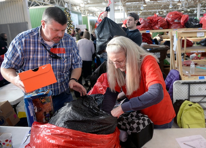 (Al Hartmann  |  The Salt Lake Tribune) 	Salt Lake School District volunteer Mike Harman, left, and Salt Lake City Corps vounteer Ruth Ann Majnik  fill a Christmas present order for a family in need at the Salvation Army's Angel Tree distribution warehouse at the Utah State Fairgrounds.   Needy families living in the Salt Lake School District picked up their bags of presents Friday Dec. 22, just in time for Christmas. 