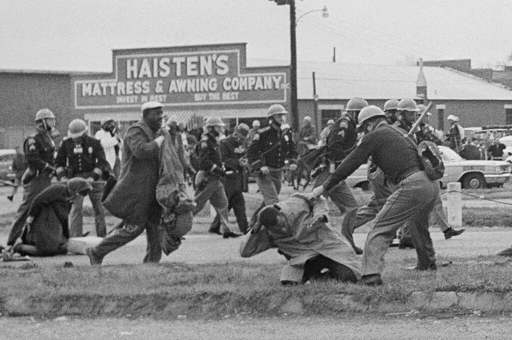 FILE - In this March 7, 1965, file photo, a state trooper swings a billy club at John Lewis, right foreground, chairman of the Student Nonviolent Coordinating Committee, to break up a civil rights voting march in Selma, Ala. Lewis sustained a fractured skull. Lewis, who carried the struggle against racial discrimination from Southern battlegrounds of the 1960s to the halls of Congress, died on July 17, 2020. (AP Photo/File)