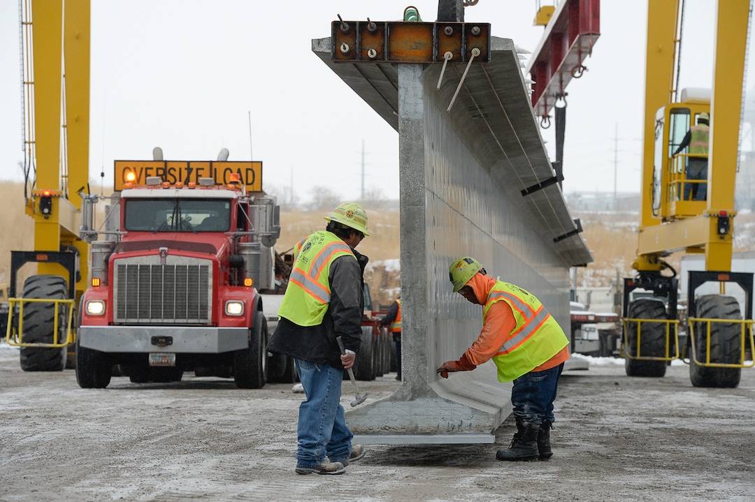 (Francisco Kjolseth  |  The Salt Lake Tribune)  UDOT gets ready to place some of the world's largest-ever bridge beams, and the largest in Utah state history with a span of 203 ft long and just over 8 ft tall, as crews load one on a truck following manufacturing at Forterra Structural Precast in Kearns on Tuesday, Dec. 11, 2018. A total of six beams will be installed in the technology corridor in Lehi later this week.